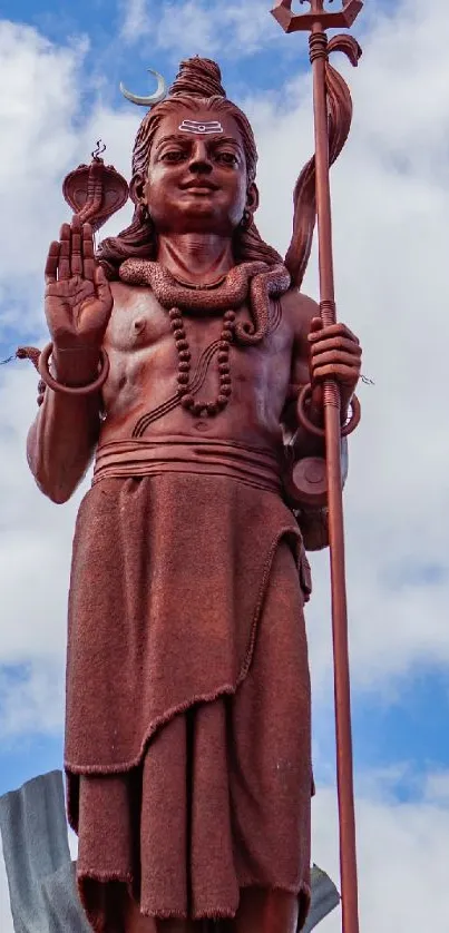 Bronze statue of Shiva against a blue sky.