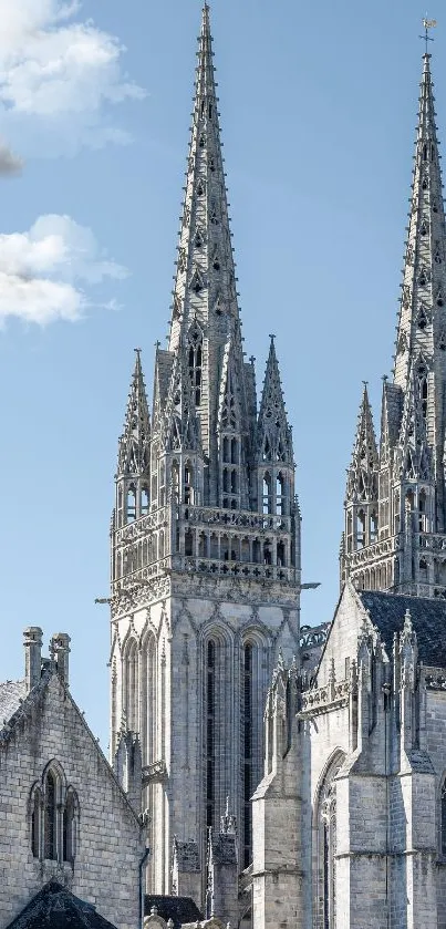 Gothic cathedral spires rise beneath a clear blue sky, showcasing architectural beauty.