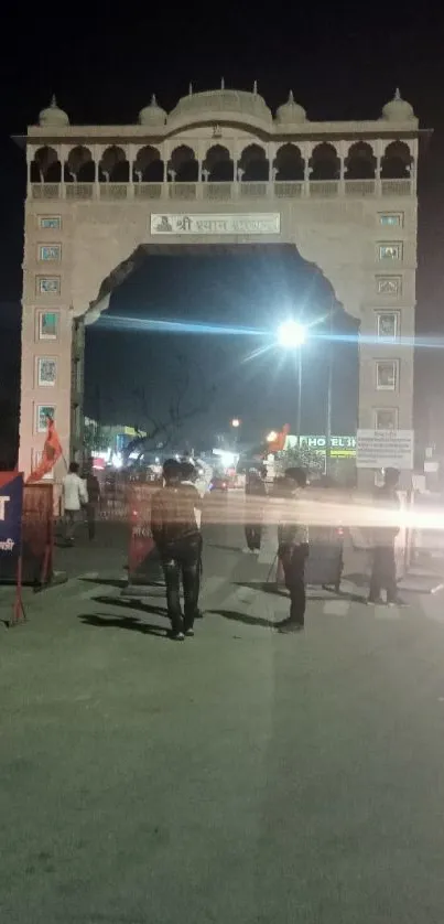 Night view of a historic city gate with street lights.