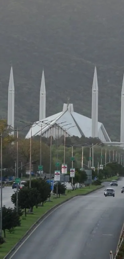 City mosque with minarets and lush green background.