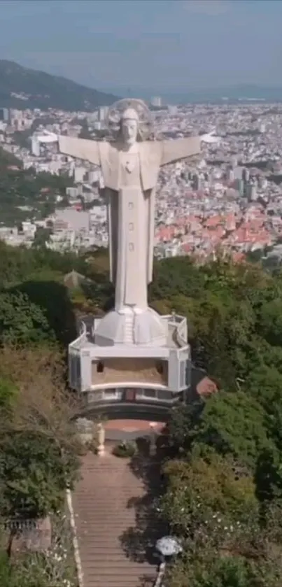 Aerial view of a grand statue overlooking a vibrant cityscape.