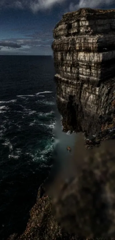 Majestic sea cliff under a moody sky with dark ocean waves.