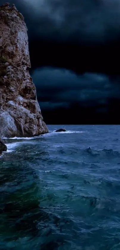 Rocky coast under a dark night sky with ocean waves.