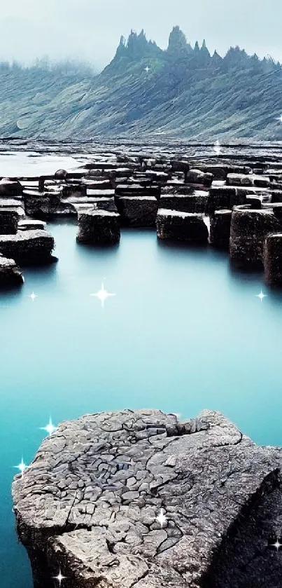 Coastal rock formations with blue water and mountain view.