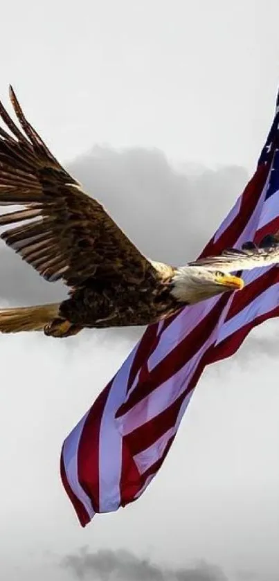 Eagle flying over American flag with cloudy sky.