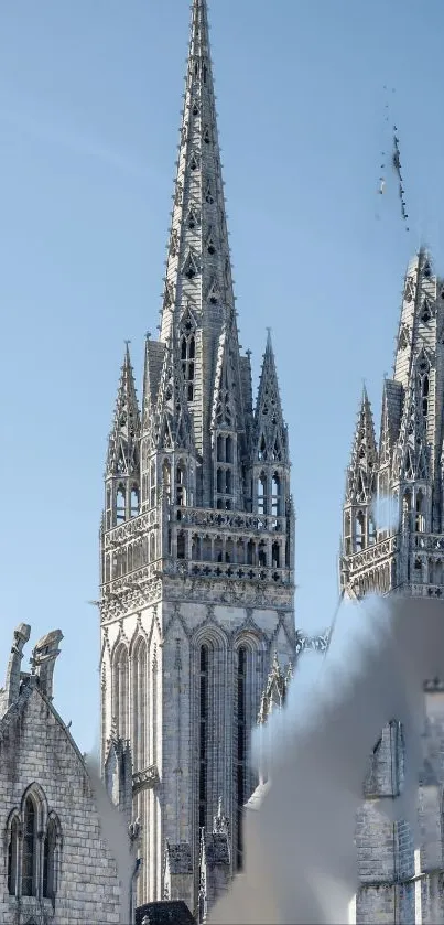 Gothic cathedral spires against a clear blue sky.