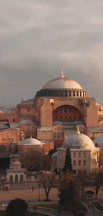 Hagia Sophia at sunset with domes and minarets, bathed in warm golden light.