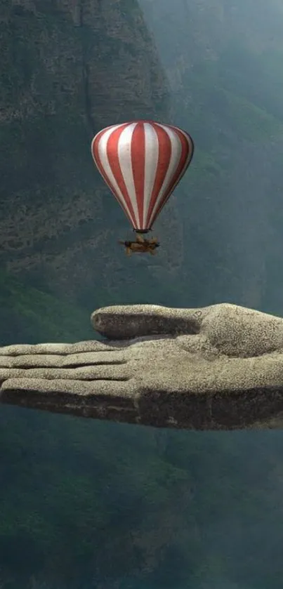 Stone hand with hot air balloon against canyon background.