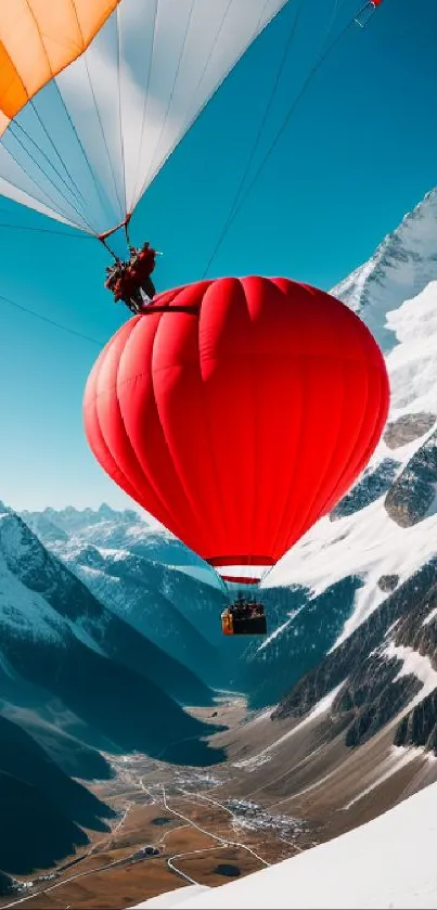 Red hot air balloon over snowy mountains at sunrise.