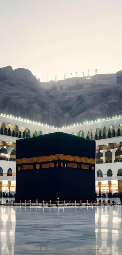 Kaaba in Mecca under the evening sky with mountaintops in the background.