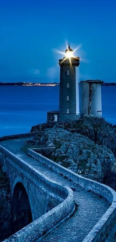 Lighthouse illuminated at dusk on a coastal cliff.