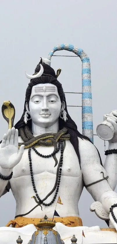 Majestic statue of Lord Shiva against a light grey sky.