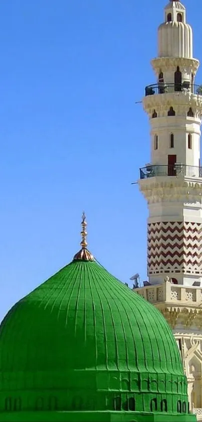 A stunning green mosque dome with minaret against blue sky.