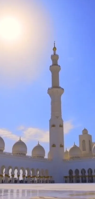 Majestic mosque under a vibrant blue sky with a bright sun overhead.