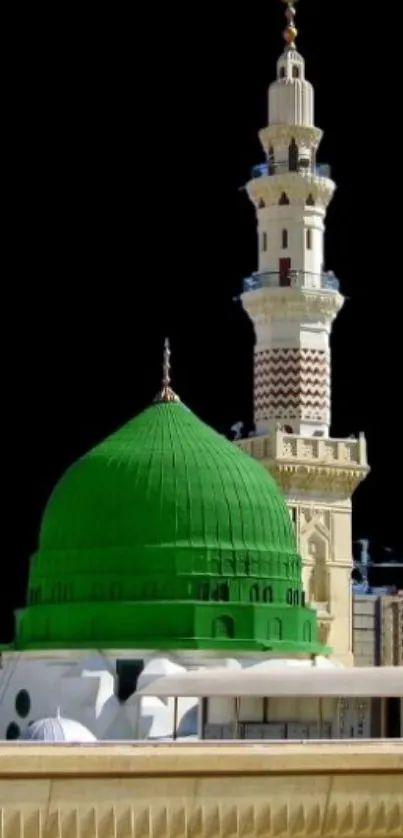 Green mosque dome with minaret and black background.