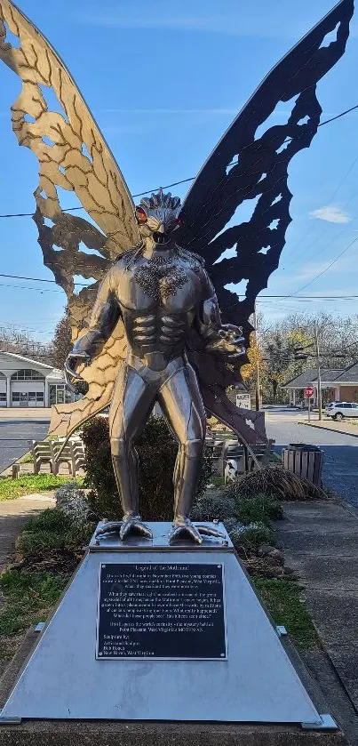 Majestic Mothman statue with urban backdrop.