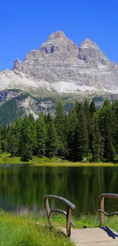 Calm lake with mountain and forest scenery under a clear blue sky.