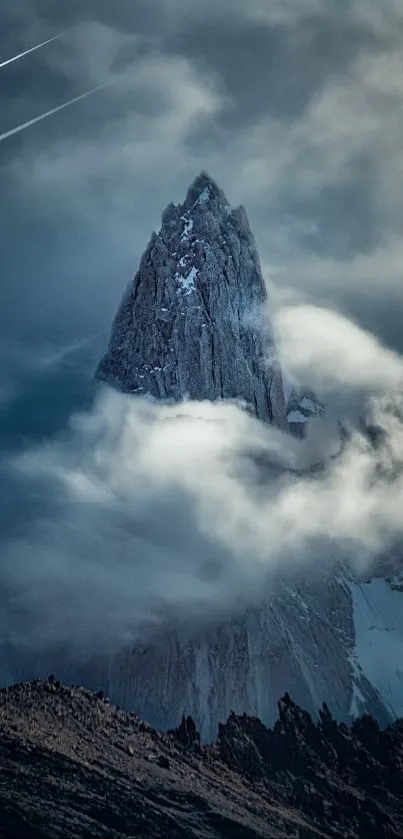 Majestic mountain peak shrouded in clouds with a dramatic sky backdrop.