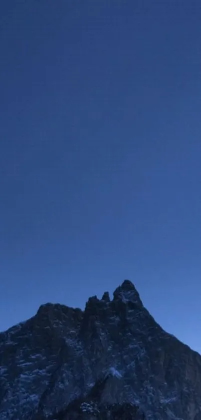 Majestic mountain at dusk under a deep blue sky.