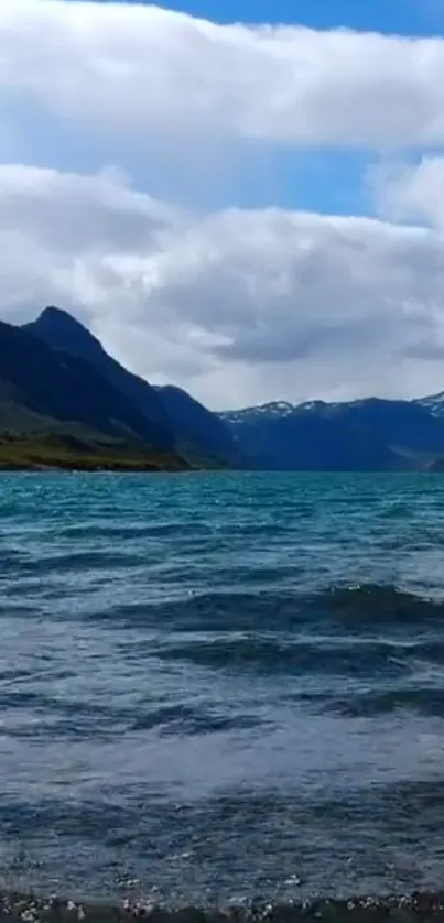 Majestic view of a mountain lake with blue sky and clouds.