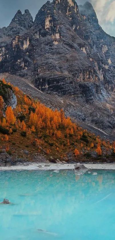 Mountain peak with autumn foliage by a teal lake.