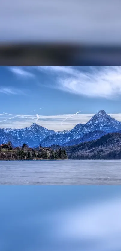 Majestic snowy mountain reflecting in a tranquil lake under a blue sky.