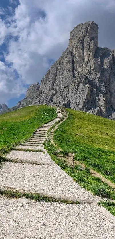 Pathway leading to rocky mountain under a blue sky.