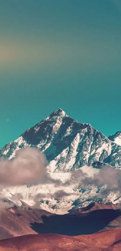 A majestic snow-capped mountain under a teal sky with serene clouds.