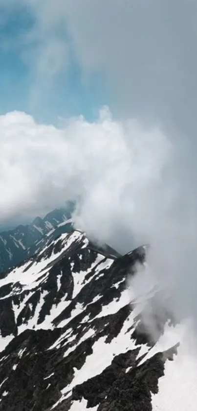 Snowy peaks with clouds covering mountains.