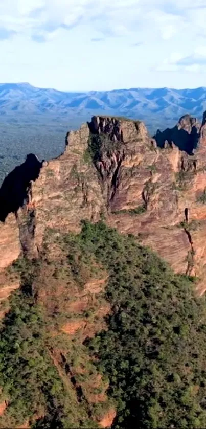 Majestic mountain cliffs with lush greenery and distant blue ridges.