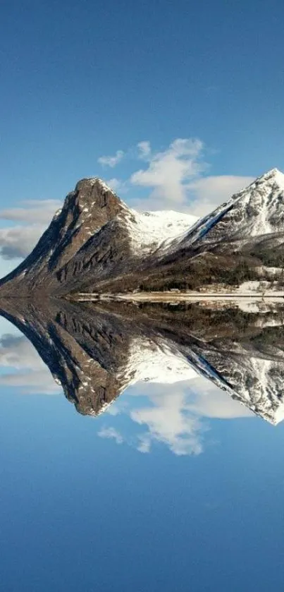 Majestic mountain reflection on serene waters under a clear blue sky.