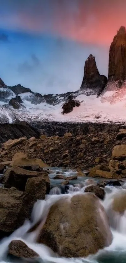 Majestic mountain sunset with vibrant sky and flowing stream.