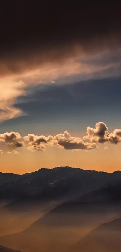 Dramatic sunset over dark mountain peaks with glowing clouds.