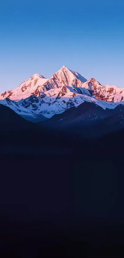 Mountain range at sunset with a serene sky.