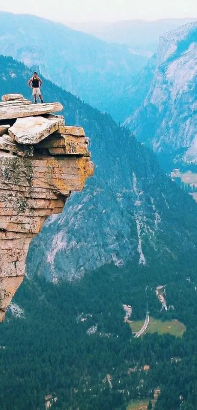 Person standing on a cliff with a majestic mountain view.