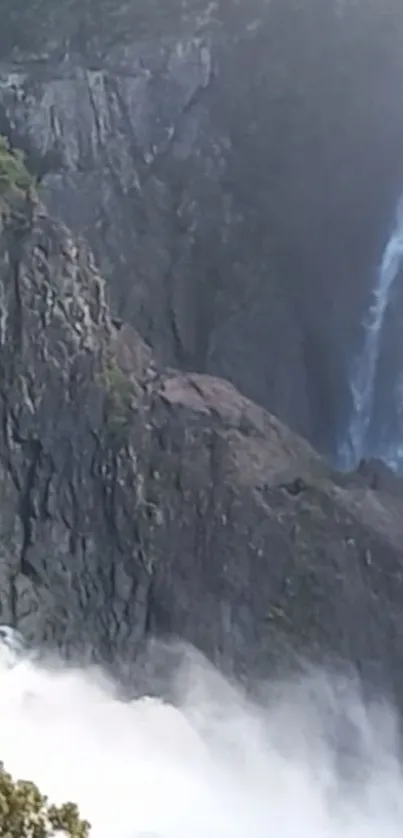 Majestic waterfall over rocky mountain cliffs and misty spray.