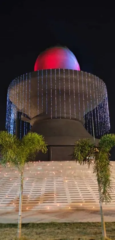 Majestic sculpture illuminated at night with vibrant lights and surrounding trees.