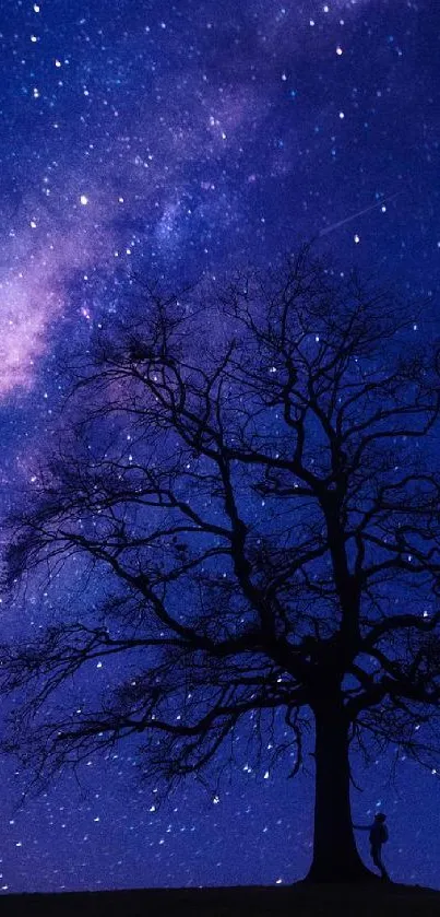 Starry night sky with silhouetted tree and Milky Way.