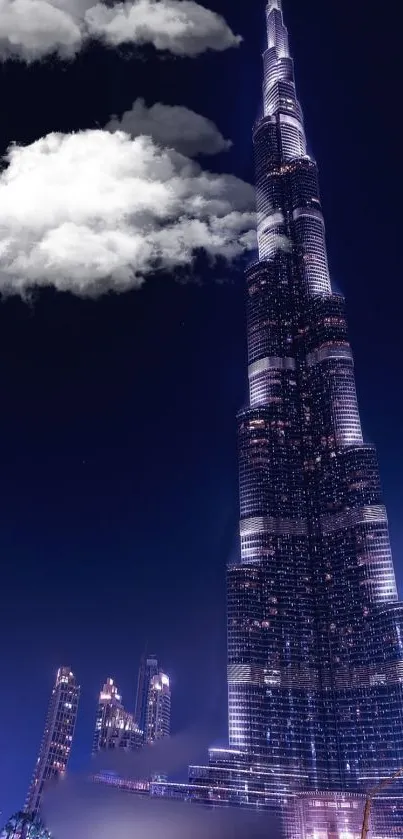 Skyscraper at night with clouds and city lights.