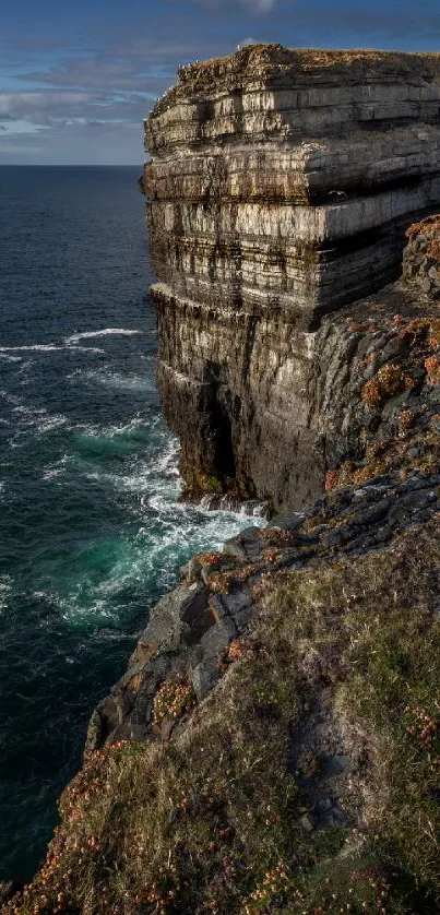 Majestic ocean cliff with deep blue waters and rugged rocks.