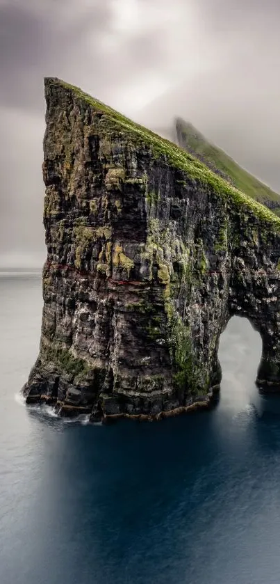 Majestic ocean cliff with mist and deep blue water backdrop.