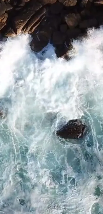 Aerial view of ocean waves crashing against rocky shoreline.