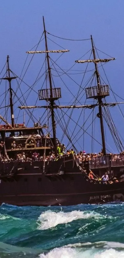 Pirate ship sailing on the blue ocean with clear sky.