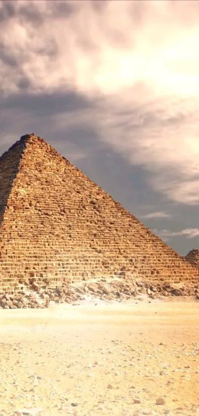 Majestic pyramid in a sandy desert under a cloudy sky.