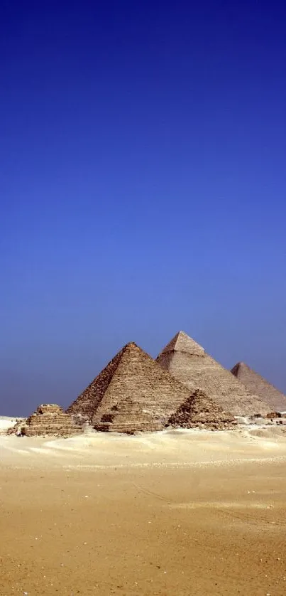Egyptian pyramids under a vast blue sky in a serene desert landscape.