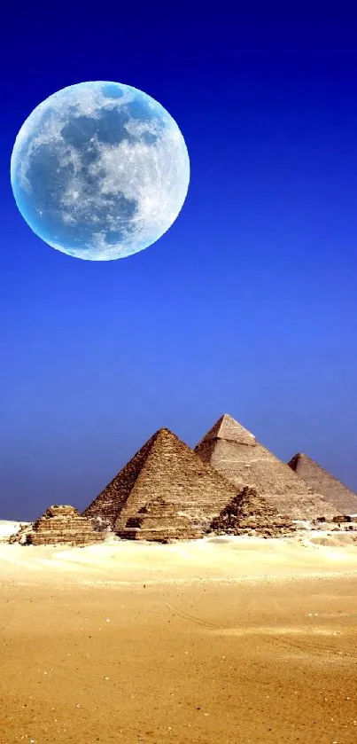 Pyramids under full moon in desert landscape wallpaper.