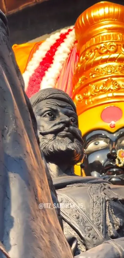 Majestic sculpture with colorful deity background.