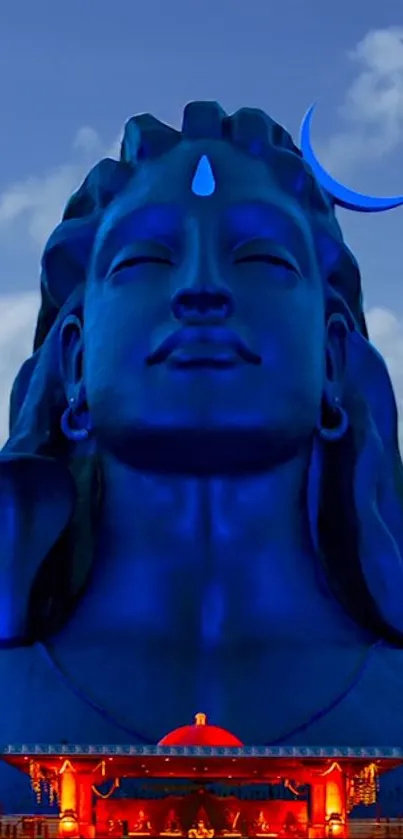 Blue Shiva statue with serene sky background for mobile wallpaper.