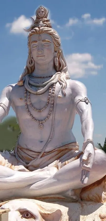 Majestic Shiva statue under a serene blue sky wallpaper.