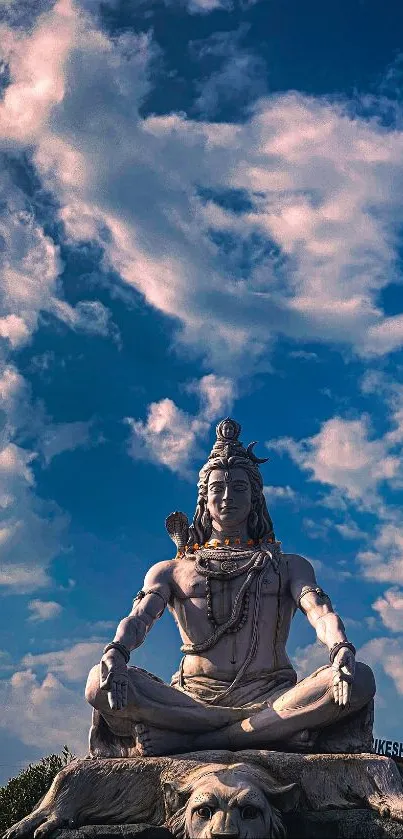 Mobile wallpaper of Shiva statue under blue sky.